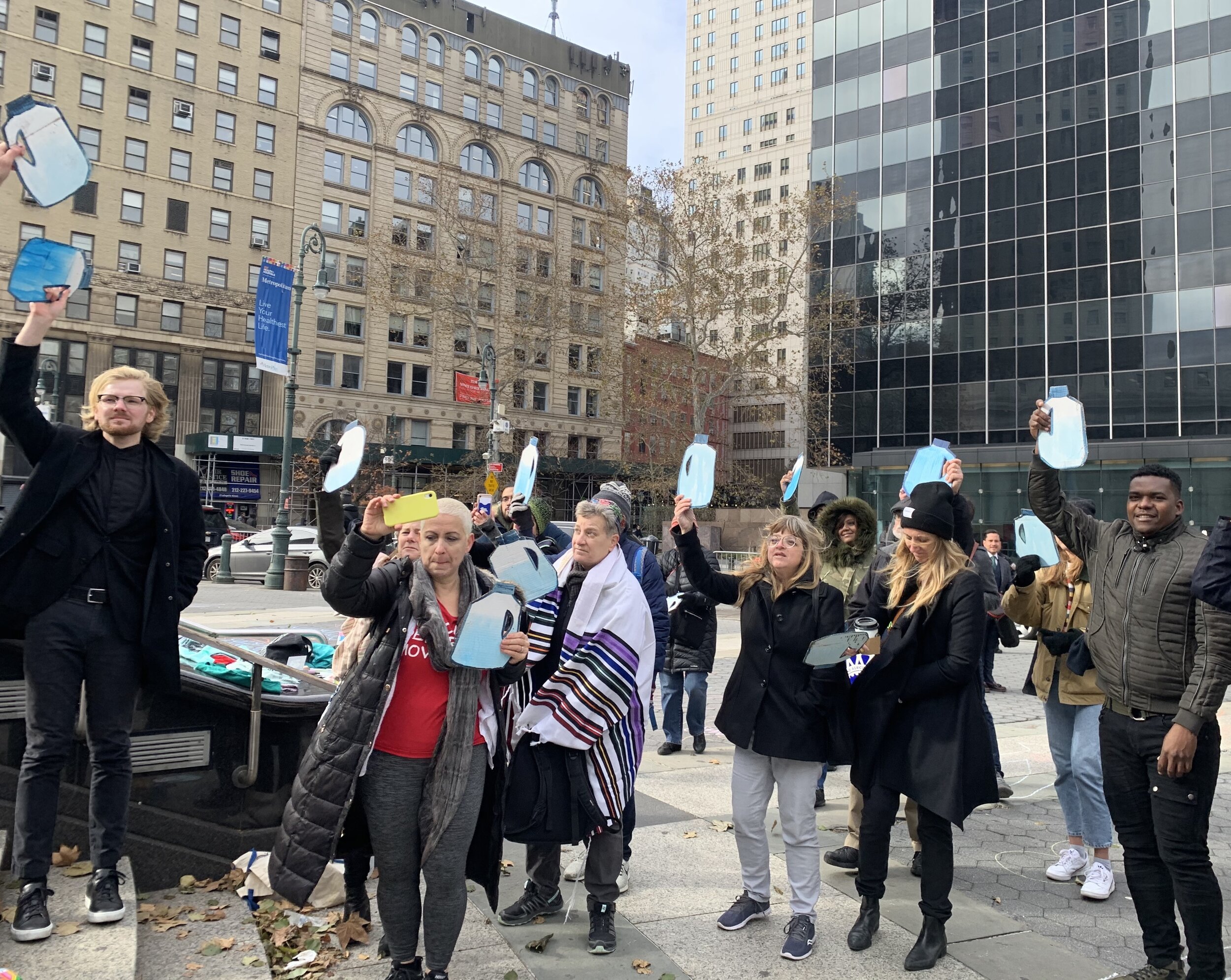 Scott Warren supporters rally in Manhattan with cardboard water jugs on Nov. 20, 2019. Pablo Suazo is seen on the far right. Photo Credit: Jude Joffe-Block