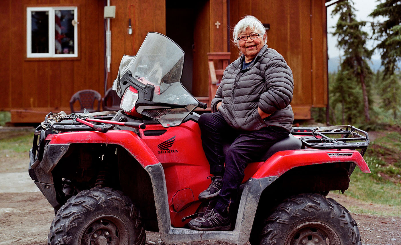 Gwich’in elder Sarah James in front of her old cabin in her hometown, Arctic Village, AK.
