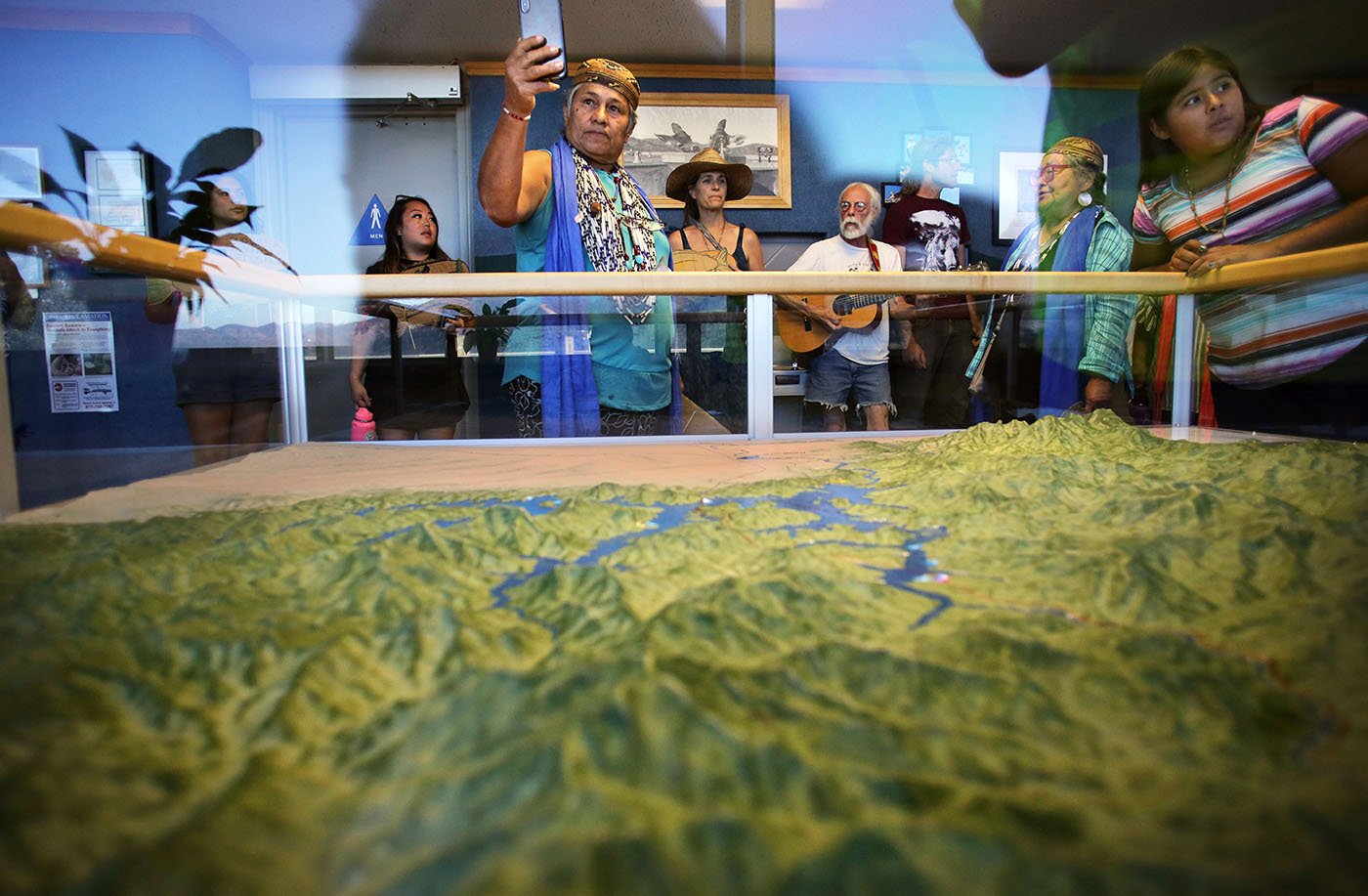 Shasta Lake, CA — Chief Caleen Sisk photographs the topographic map of Shasta Dam and its tributaries including the McCloud River, homeland of the Winnemem Wintu people. September 25, 2019. Tom Levy/The Spiritual Edge