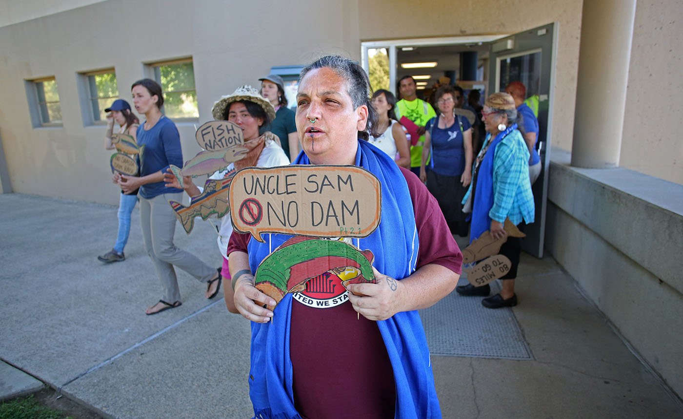 Shasta Lake, CA — As they leave the Shasta Dam Visitor Center, protestors sing a song that asks the U.S. Bureau of Reclamation to build a swimway so salmon can reach the rivers above the dam. September 25, 2019. Tom Levy/The Spiritual Edge
